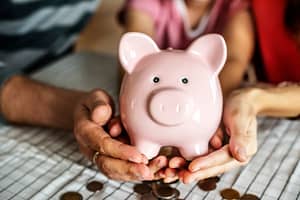 a pig money box and some coins below