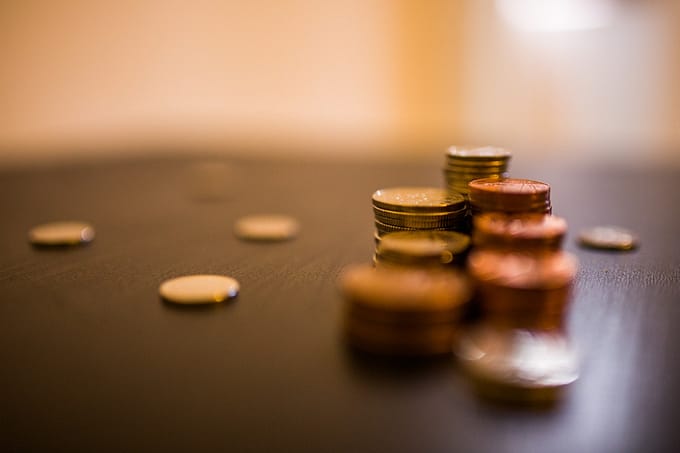stack of golden coins on the wooden table